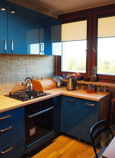 Ciemna kuchnia w zestawieniu z dużymi oknami